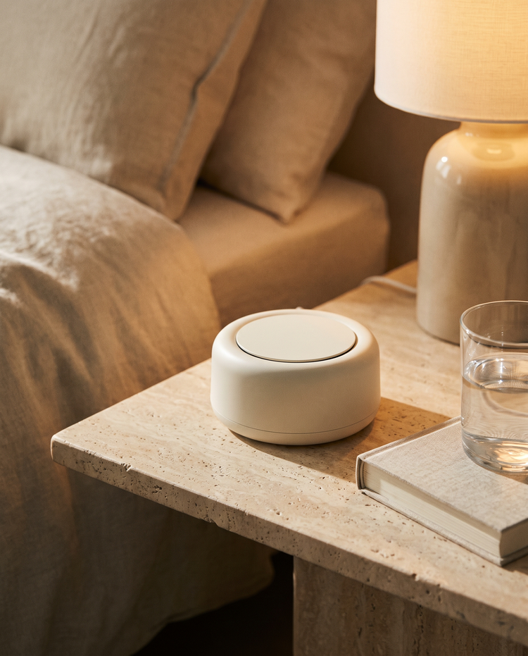 Ivory sound machine on a travertine nightstand